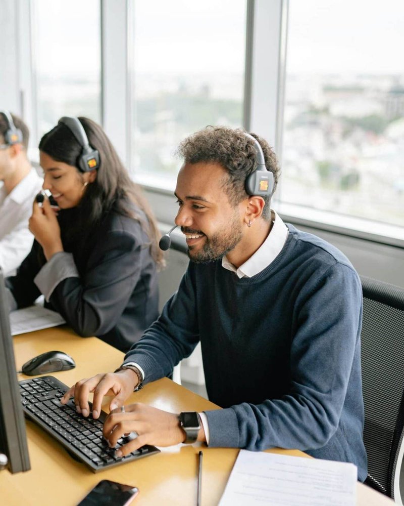 Equipo de soporte técnico atendiendo con auriculares frente a sus computadoras